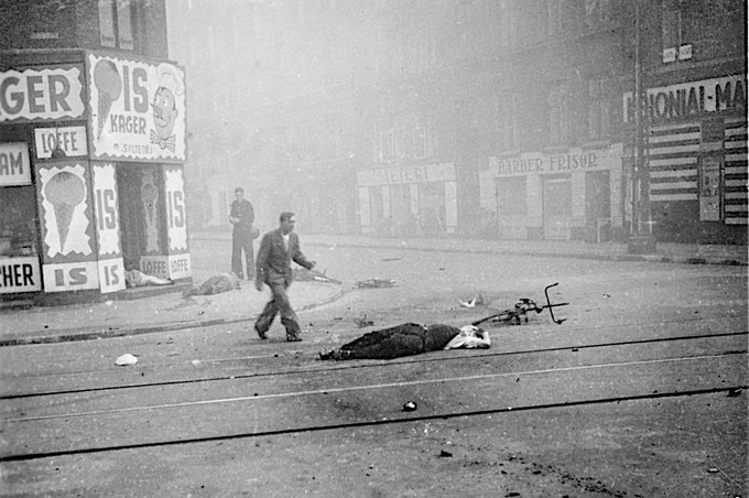 A woman and two men lie dead on a street corner in the workers’ district of Nørrebro